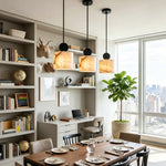 Sabine Alabaster Drum Pendant Light | Natural Alabaster and Brass | Multiple fixtures hanging over a long wooden dining or study table next to a large library bookshelf | Severn Lighting