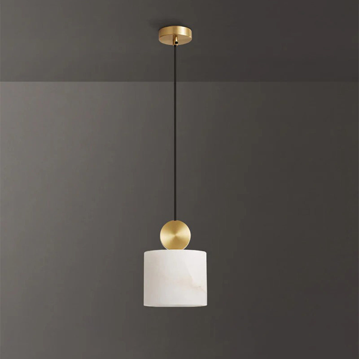 Sabine Alabaster Drum Pendant Light | Natural Alabaster and Brass | Standard studio single product view hanging unlit against a solid dark grey minimalist background | Severn Lighting