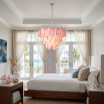 Seraphina Rose Glass Petal Chandelier | Glass, Metal | Installed as grand overhead lighting in a serene master bedroom with a large bed, neutral linens, and bright balcony doors | Severn Lighting
