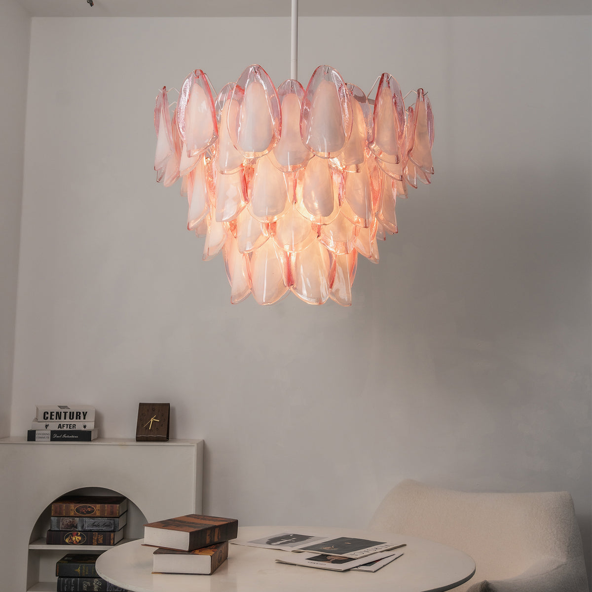 Seraphina Rose Glass Petal Chandelier | Glass, Metal | Staged in a contemporary minimalist dining alcove corner, projecting a soft glow over a round white lounge table | Severn Lighting