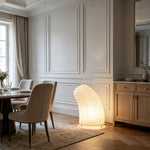 Severine Spiral Washi Paper Table Lamp | Washi Paper and Metal | Glowing warmly on the floor in an elegant dining room | Severn Lighting