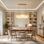 Sirena Capiz Elongated Linear Chandelier | Capiz Shell, Metal | Suspended above a long wooden table in an elegant multi-functional room with floor-to-ceiling built-in bookcases | Samu Lamp