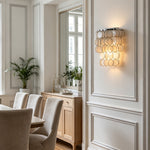 Sirena Capiz Tiered Wall Sconce | Capiz Shell, Metal | Mounted on a wall above a wooden sideboard cabinet in an elegant classic dining room | Samu Lamp