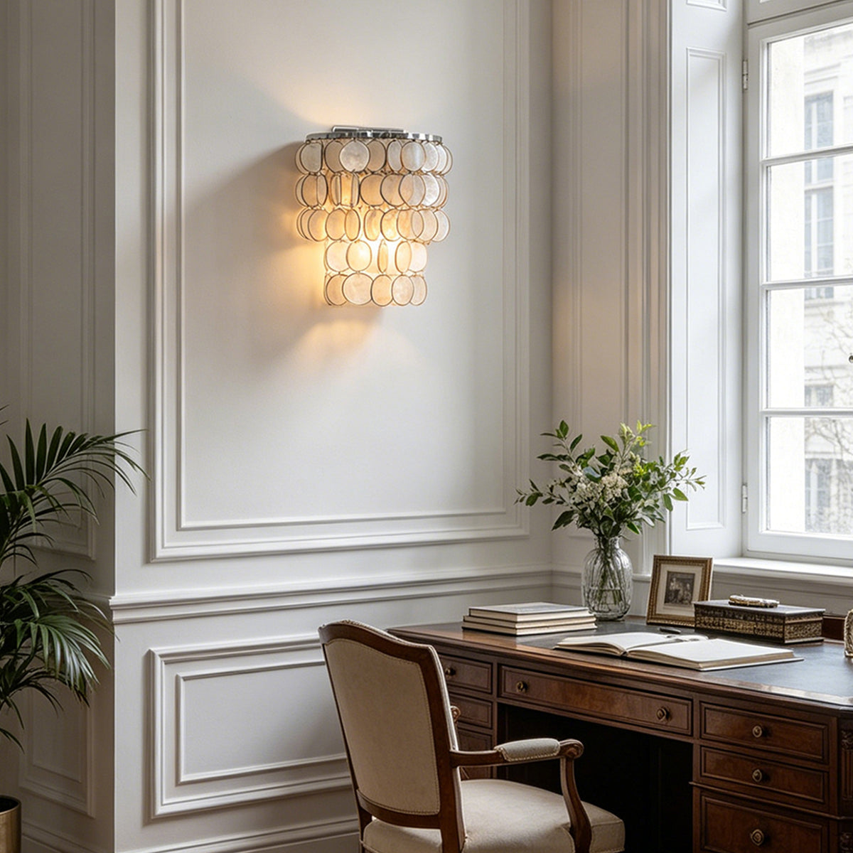 Sirena Capiz Tiered Wall Sconce | Capiz Shell, Metal | Illuminating a home office workspace setup on a wall adjacent to a classic wooden writing desk | Samu Lamp