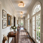 Solaine Alabaster Dome Ceiling Light | Natural Alabaster and Brass | Row of flush mount lights lining a long arched hallway corridor | Severn Lighting