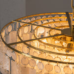 Thalassa Tiered Capiz Shell Chandelier | Capiz Shell, Metal | Top-down internal view showing the multi-tiered circular gold brass frame concentric structure and ceramic light bulb sockets | Detail shot | Severn Lighting
