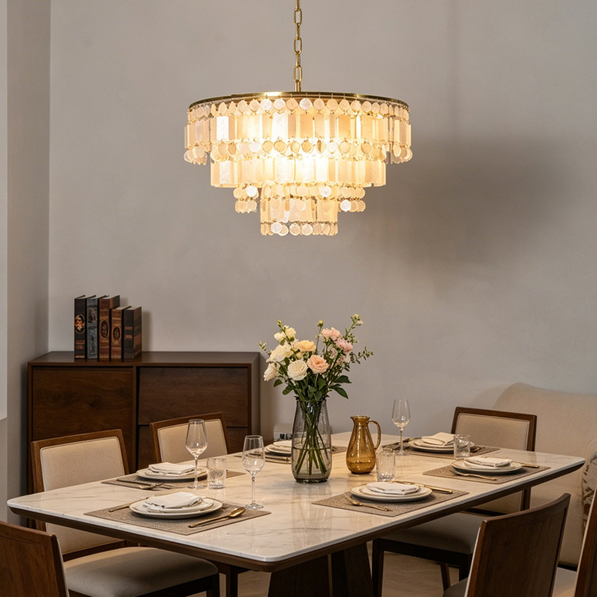 Thalassa Tiered Capiz Shell Chandelier | Capiz Shell, Metal | Suspended over an elegant contemporary white dining table and chairs set next to a dark wood sideboard cabinet | Severn Lighting