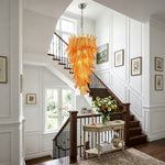 Thessaly Amber Glass Plume Chandelier | Amber Glass and Brass | Hanging above a wooden staircase in an elegant entryway | Severn Lighting