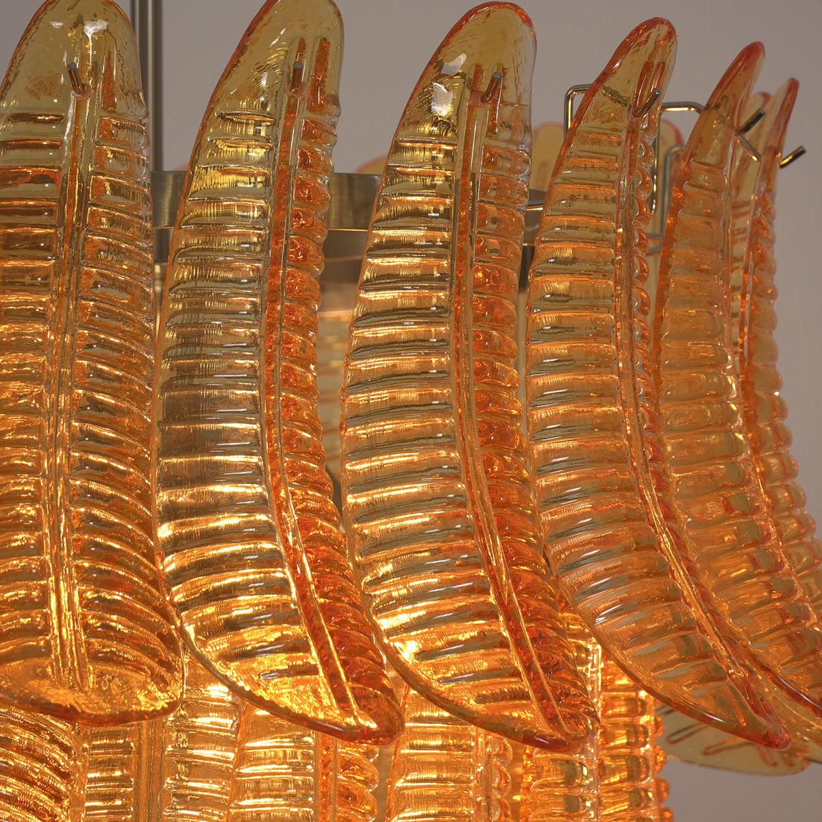 Thessaly Amber Glass Plume Chandelier | Amber Glass and Brass | Close-up view highlighting the curved feather-like glass textures | Severn Lighting