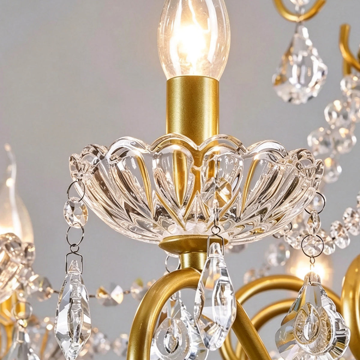 Torvald Scrolled Crystal Brass Chandelier | Cut Crystal and Brass | Close-up detail of the candle bulb, crystal bobeche, and brass arm | Severn Lighting