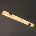 Vale Alabaster Linear Glow Pendant Lighting | Natural Alabaster and Black Metal | Angled studio display of the lit linear alabaster pendant fixture against a dark wall | Severn Lighting