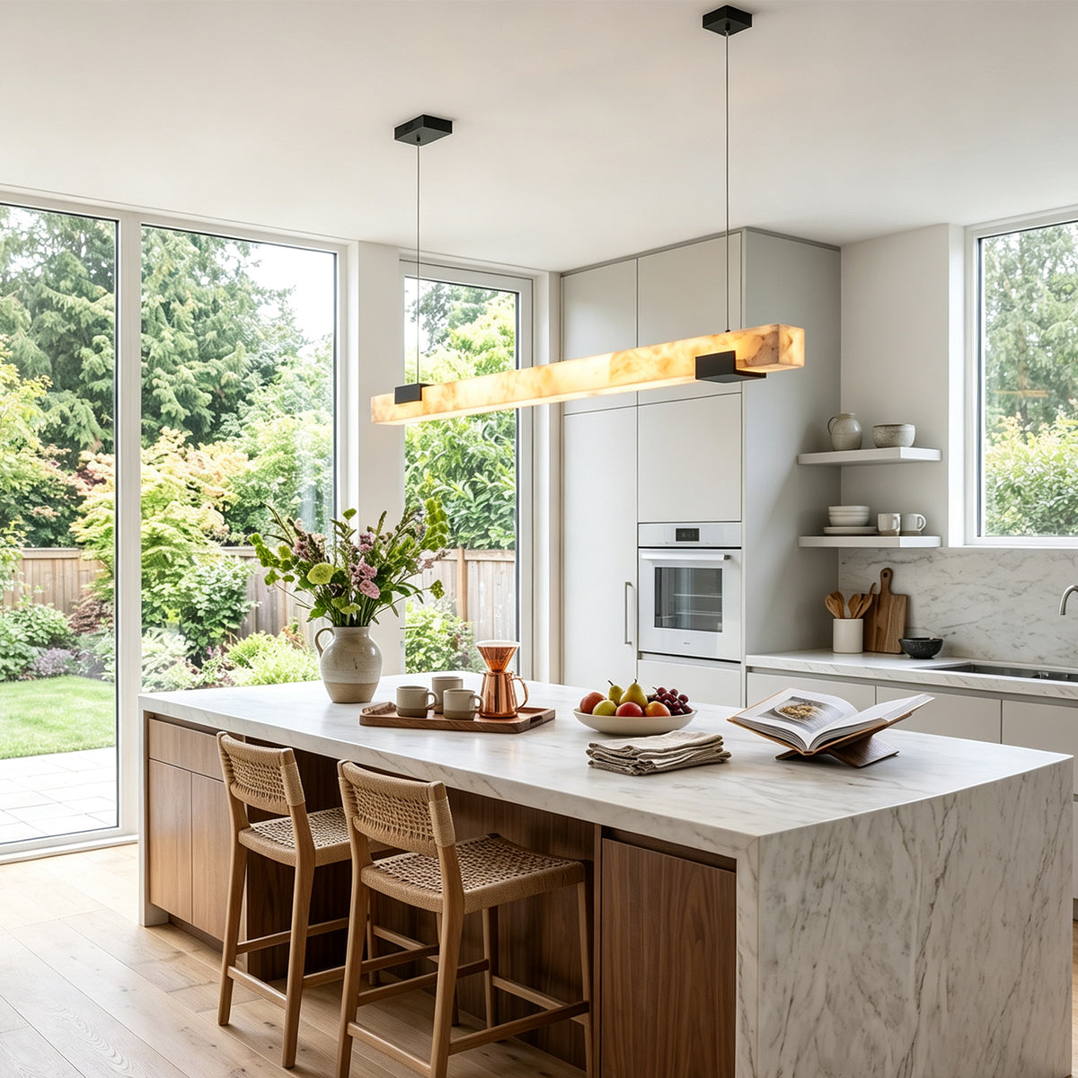 Vale Alabaster Linear Glow Pendant Lighting | Natural Alabaster and Black Metal | Hanging over a modern marble kitchen island in a bright sunlit kitchen space | Severn Lighting