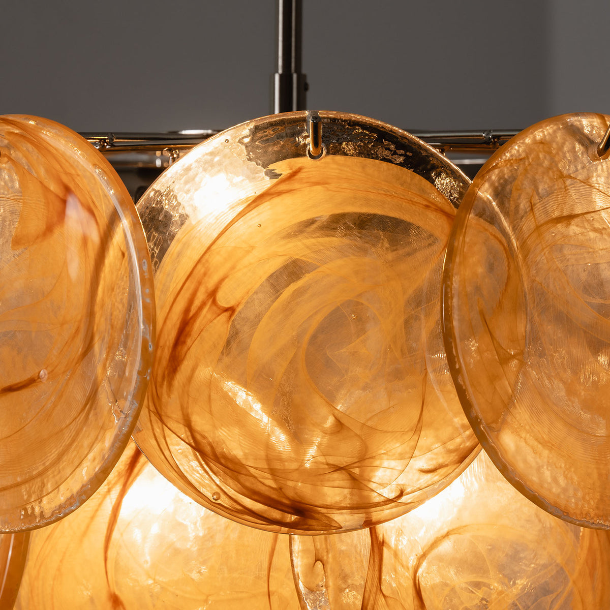 Vaucelle Swirled Glass Disc Tiered Chandelier | Swirled Glass and Brass | Close-up shot of yellow amber swirled glass discs on brass hooks | Severn Lighting