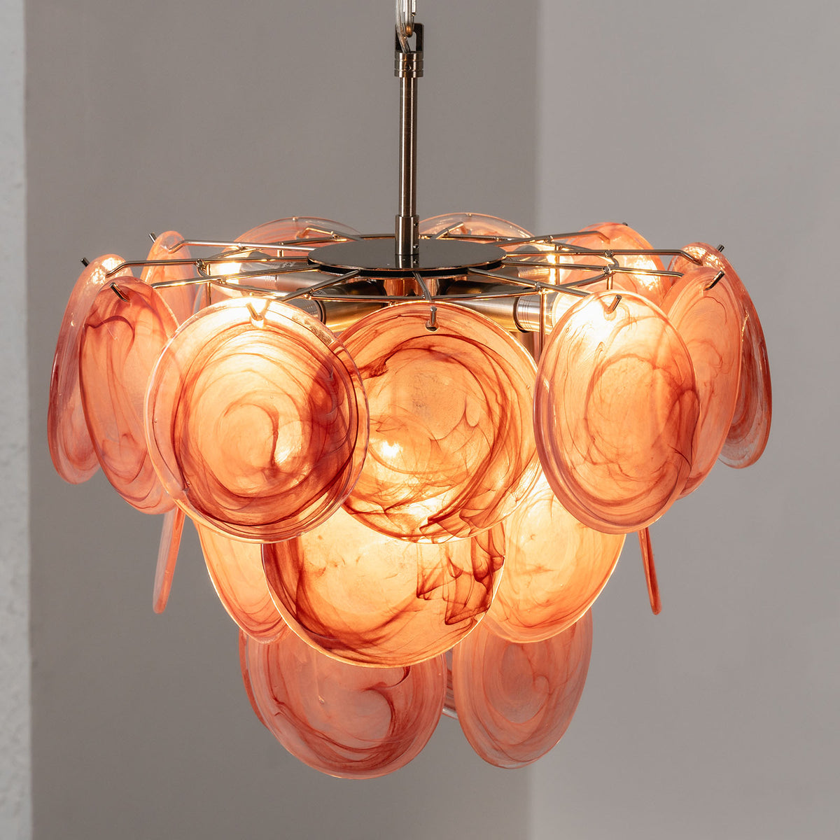 Vaucelle Swirled Glass Disc Tiered Chandelier | Swirled Glass and Brass | Reddish-orange swirled glass variant illuminated on neutral backdrop | Severn Lighting