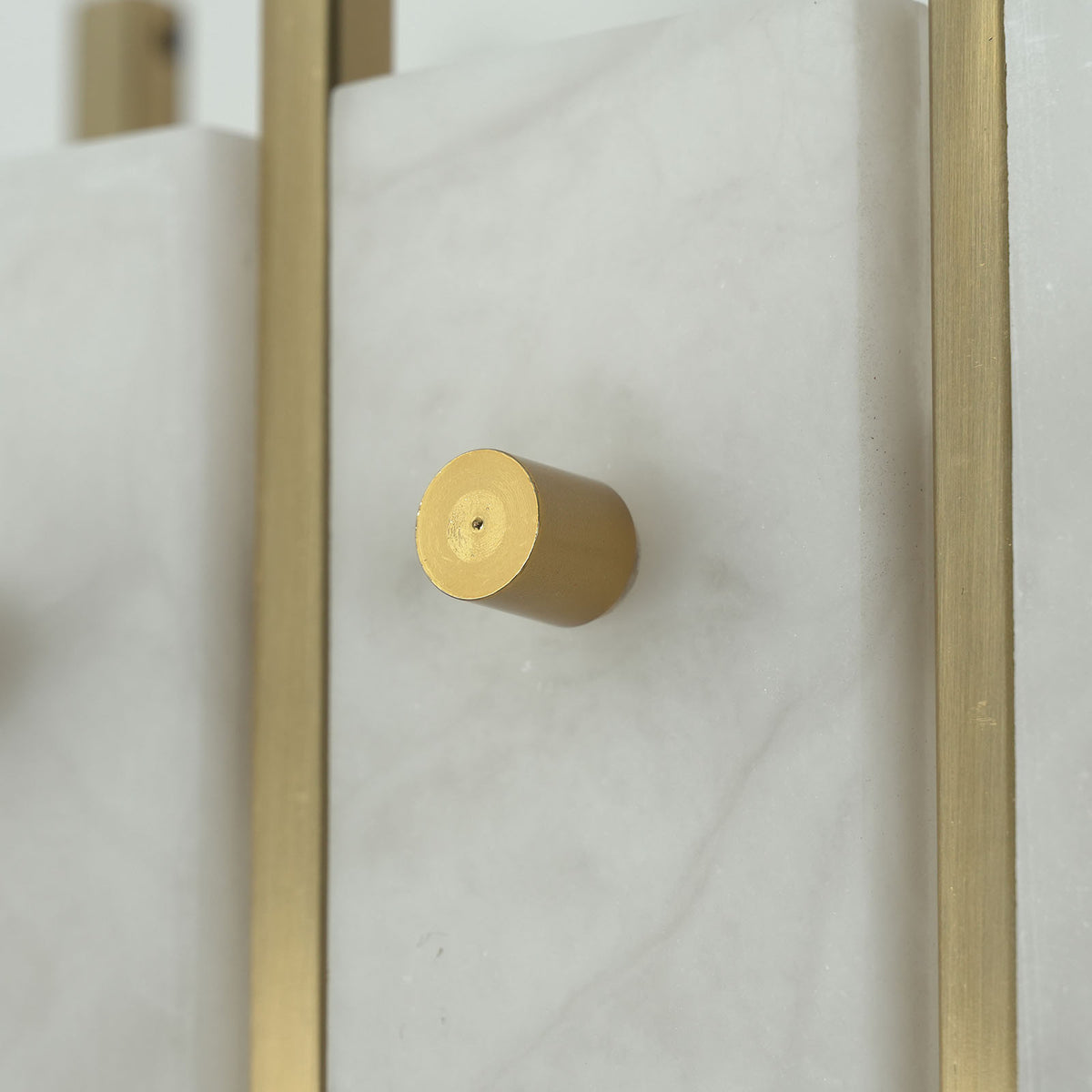 Veraune Bar Wall Sconce | Solid Brass Hardware | Macro close-up of knurled brass cap screw and stone slab | Severn Lighting