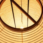 Verena Ribbed Paper Column Floor Lamp | Ribbed Paper and Metal Tripod Legs | Looking inside the lit paper shade showing the internal geometric wood bracing and wiring structure | Severn Lighting