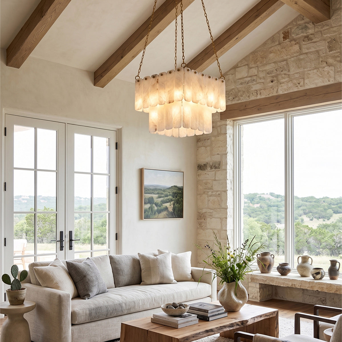 Vivienne Tiered Alabaster Chandelier | Alabaster, Brass | Providing warm ambient lighting over a cream sofa in a bright contemporary living room with exposed wood ceiling beams | Severn Lighting