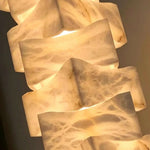 Alden Interlocking Alabaster Column Floor Lamp | Natural Alabaster and Metal | Close-up view of the glowing interlocking geometric alabaster blocks | Severn Lighting