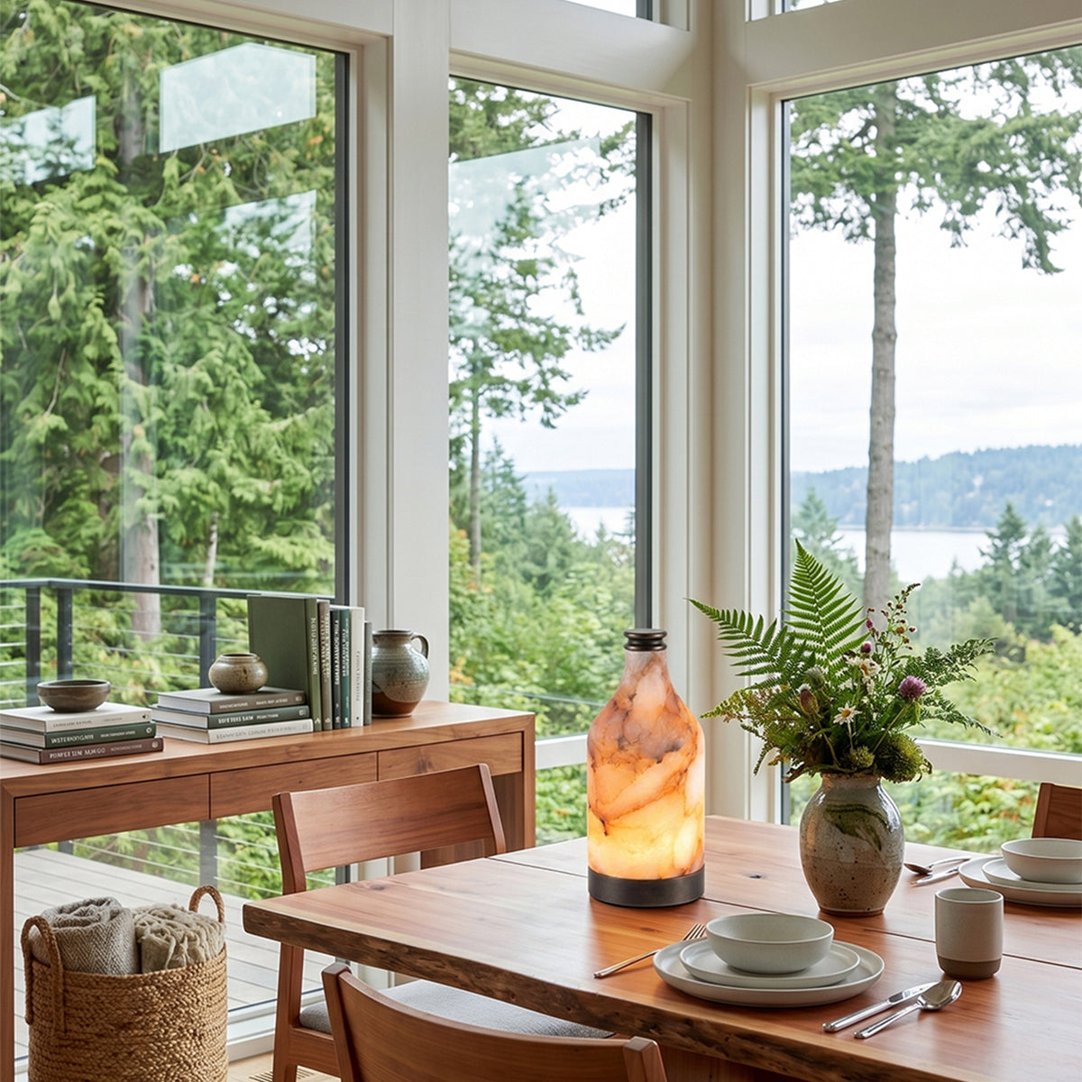 Aldric Alabaster Flask Table Lamp | Natural Alabaster Stone and Bronze Metal | Positioned on a dining table in a bright room surrounded by floor-to-ceiling forest view windows | Severn Lighting