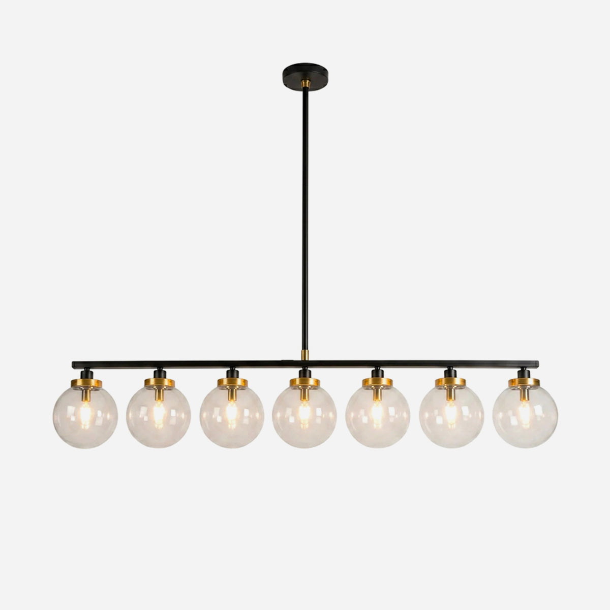 Alistair Linear Glass Globe Chandelier | Clear Glass, Brass, Metal | Isolated lit view of a modern industrial 8-light linear suspension chandelier with clear glass globes, gold brass sockets, and a sleek matte black bar | White background | Severn Lighting