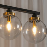 Alistair Linear Glass Globe Chandelier | Lit Bulb Detail | Macro close-up shot of the fully lit spherical clear glass globes showcasing the warm glowing bulb filaments and gold brass hardware | Detail shot | Severn Lighting
