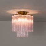 Amabel Dazzling Pink Glass Ceiling Light | Pink Glass and Brass | Studio shot showing the light glowing softly against a dark wall backdrop | Severn Lighting