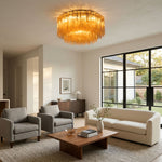 Ambleve Amber Glass Tube Flush Mount Chandelier | Fluted Amber Glass and Brass | Mounted on the ceiling of a spacious living room with beige sofas | Severn Lighting