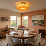 Ambleve Amber Glass Tube Flush Mount Chandelier | Fluted Amber Glass and Brass | Centered in a dining room above a round table near a coral wall | Severn Lighting