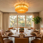 Ambleve Amber Glass Tube Flush Mount Chandelier | Fluted Amber Glass and Brass | Positioned over a round wooden dining table in a bright room | Severn Lighting
