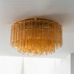 Ambleve Amber Glass Tube Flush Mount Chandelier | Fluted Amber Glass and Brass | Real-life installation view glowing softly against a white ceiling | Severn Lighting