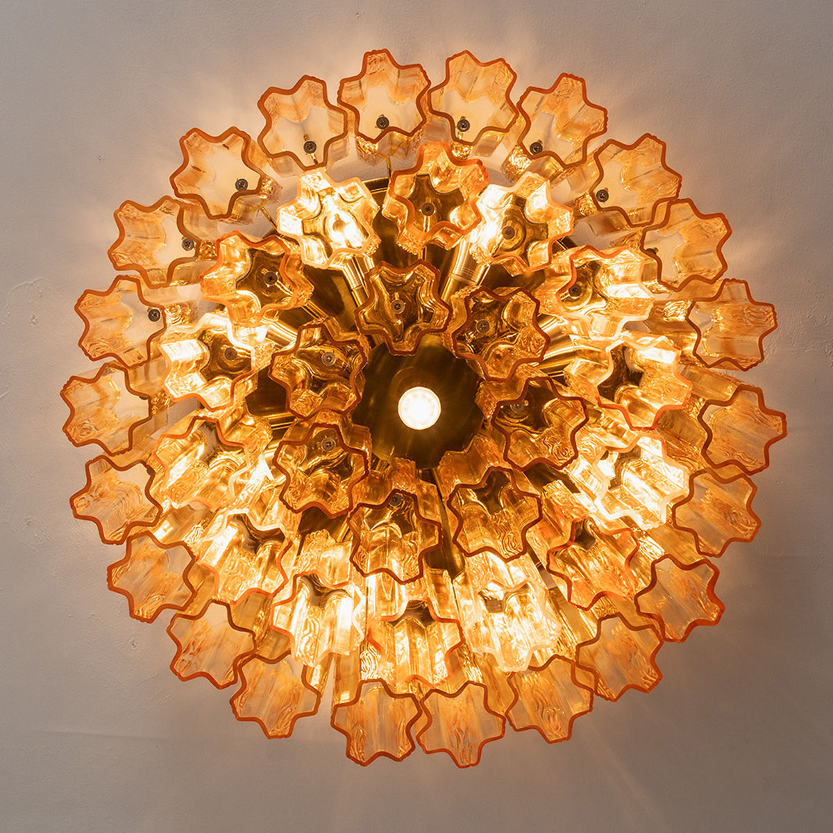 Ambleve Amber Glass Tube Flush Mount Chandelier | Fluted Amber Glass and Brass | Direct illuminated bottom-up view displaying glowing radial light pattern | Severn Lighting