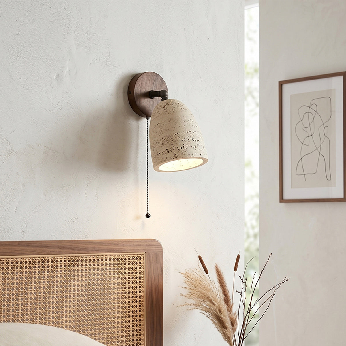 Aria Travertine Wood Wall Lamp | Travertine, Wood, Metal | Mounted on a white textured plaster wall above a woven cane headboard bed under soft natural light | Samu Lamp