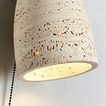 Aria Travertine Wood Wall Lamp | Travertine, Wood, Metal | Macro close-up focus on the illuminated porous travertine stone shade highlighting its natural pitted texture | Detail shot | Samu Lamp