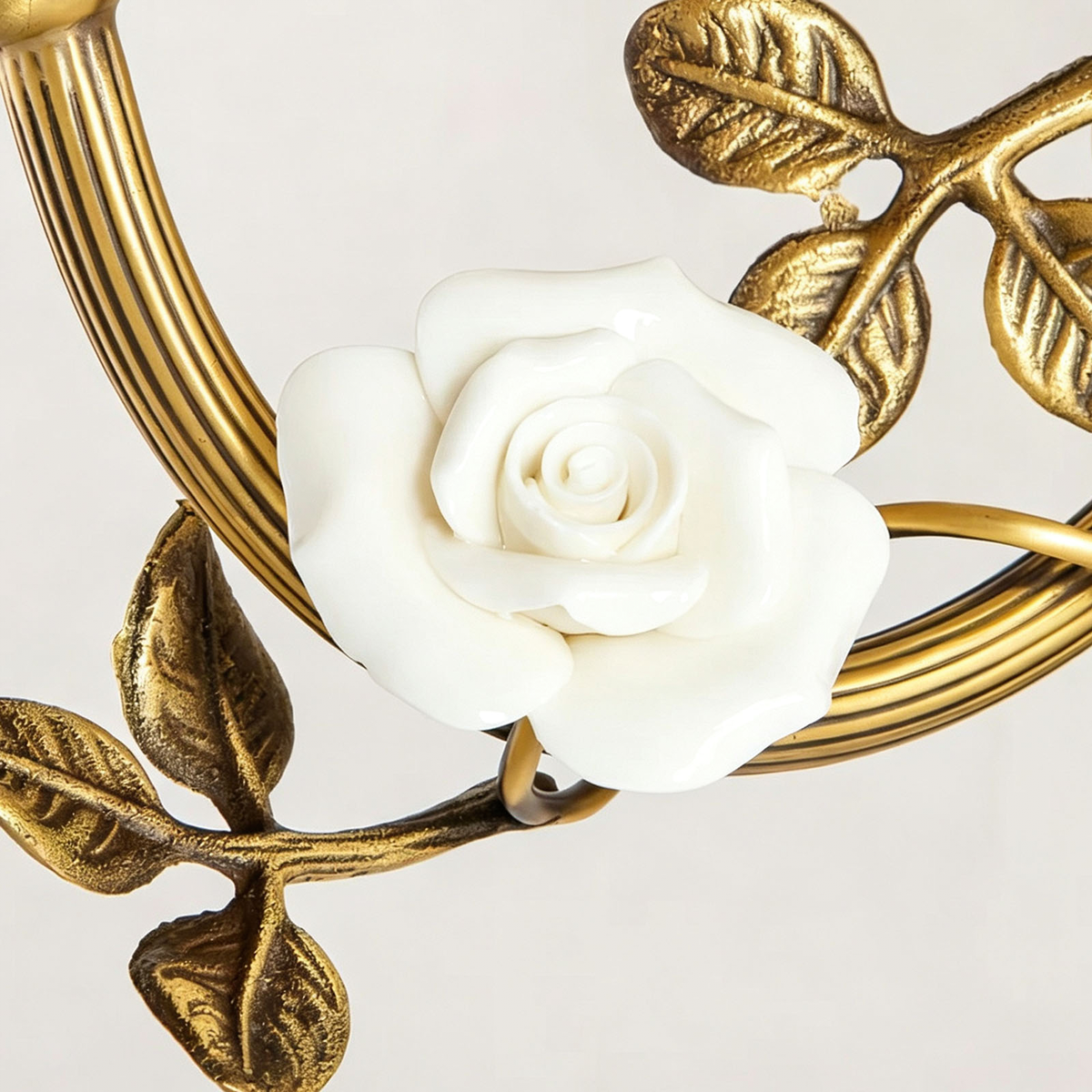 Armelle Rose Glass Brass Wall Lamp | Glass, Ceramic and Brass | Detail shot highlighting the white porcelain rose flower and brass leaves | Severn Lighting