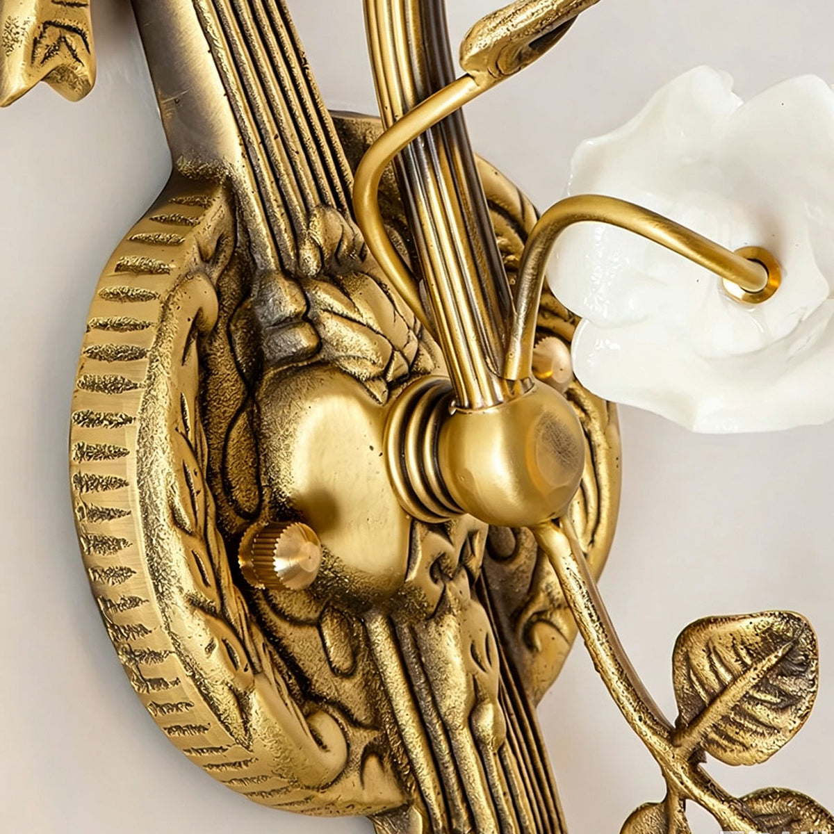 Armelle Rose Glass Brass Wall Lamp | Glass, Ceramic and Brass | Close-up detail of the carved ribbon bow brass backplate | Severn Lighting
