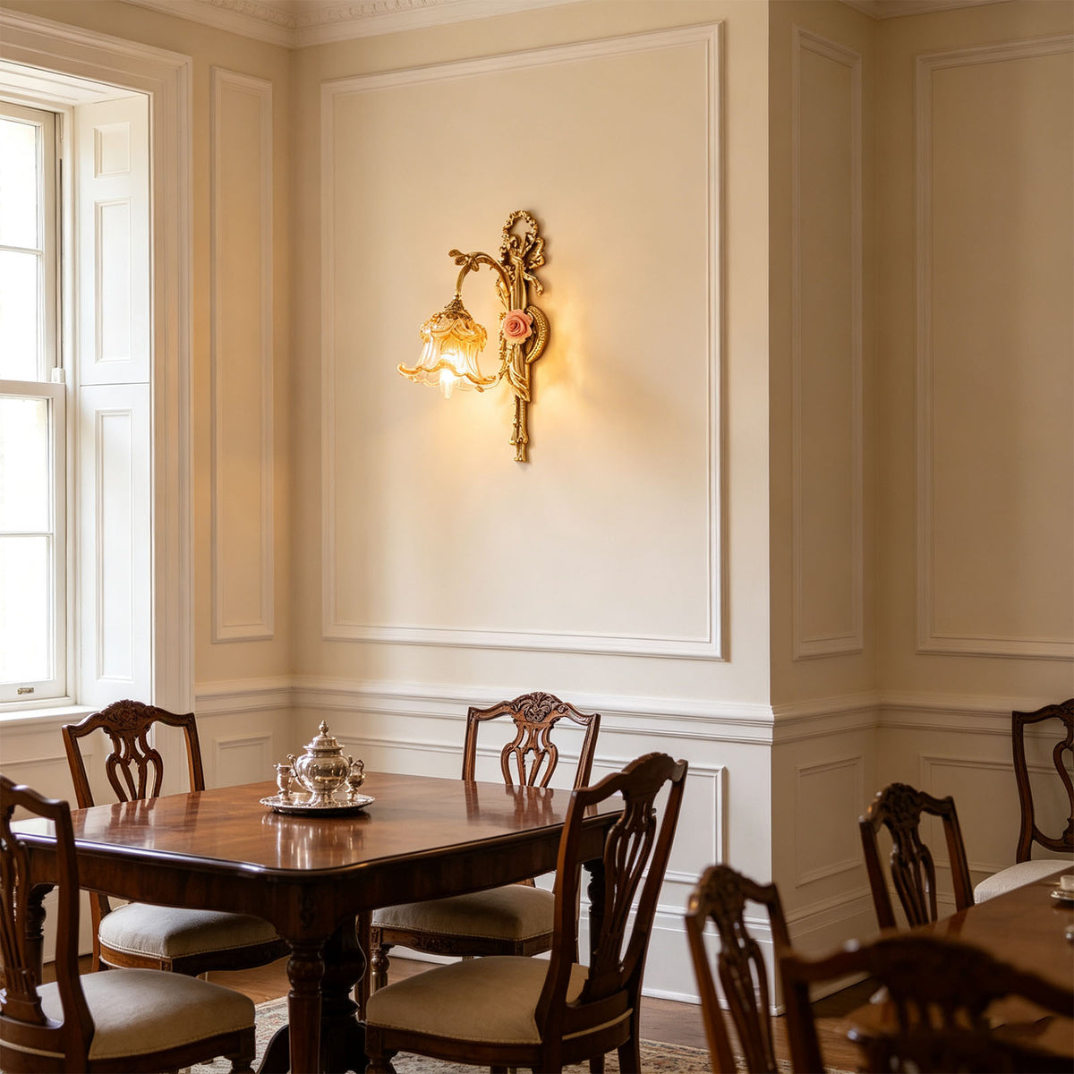 Armelle Rose Glass Brass Wall Lamp | Glass, Ceramic and Brass | Installed on a paneled dining room wall above a table with chairs | Severn Lighting