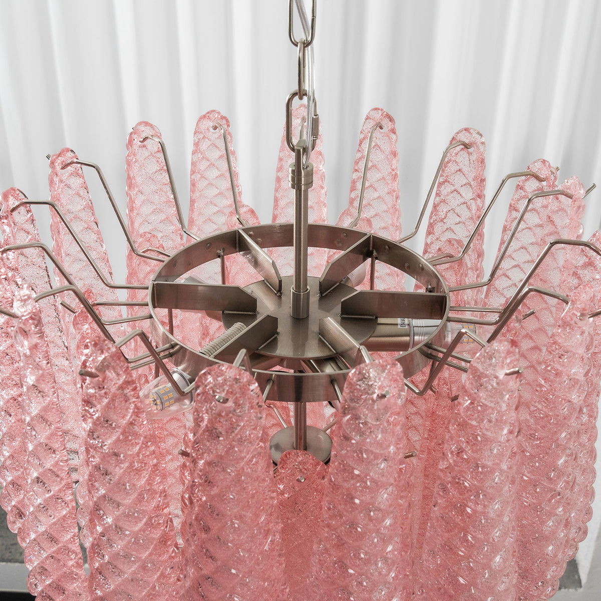 Aubine Pink Textured Glass Tiered Chandelier | Pink Textured Glass and Brass | Top-down angled view of internal brass frame with pink glass prisms | Severn Lighting