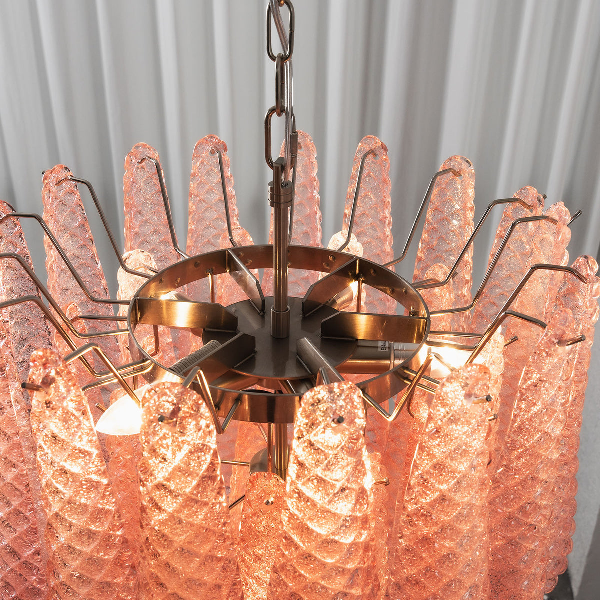 Aubine Pink Textured Glass Tiered Chandelier | Pink Textured Glass and Brass | Angled top view of glowing pink textured glass petals and inner lights | Severn Lighting