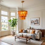 Aurelia Tiered Amber Glass Chandelier | Glass, Metal | Hanging as a grand centerpiece in a contemporary living room featuring a cream sofa, a wooden coffee table, and large bay windows | Severn Lighting