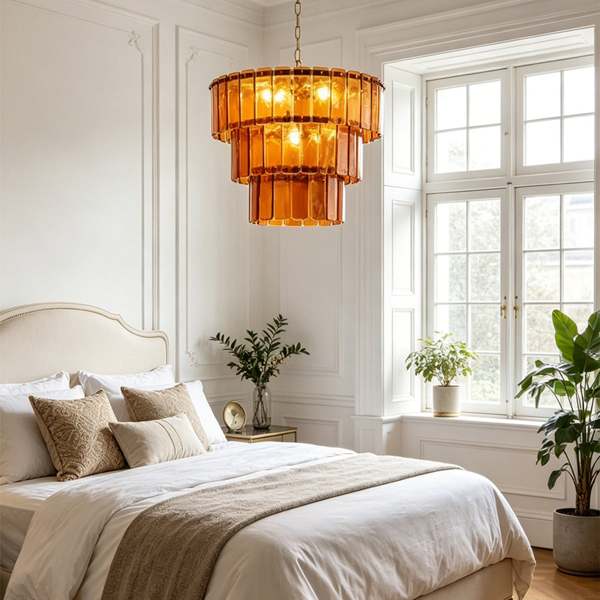 Aurelia Tiered Amber Glass Chandelier | Glass, Metal | Installed as elegant overhead bedroom lighting casting a cozy amber ambiance next to a bed with a cream headboard | Severn Lighting