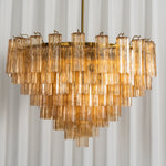 Auriane Fluted Amber Glass Chandelier | Fluted Amber Glass and Brass | Front full shot displayed against a vertical fluted wall panel | Severn Lighting