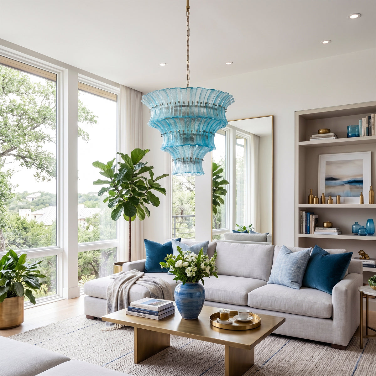 Azura Aquamarine Cascading Glass Chandelier | Glass, Metal | Providing a cozy colorful glow in a contemporary living space decorated with white couches, blue accent pillows, and built-in bookcases | Severn Lighting
