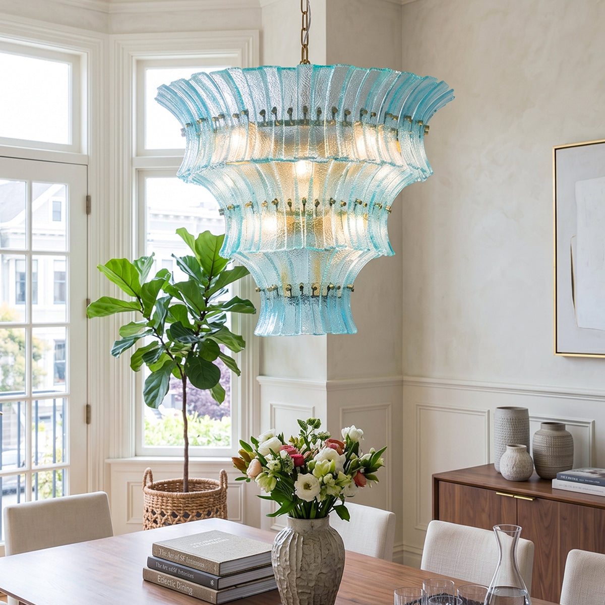 Azura Aquamarine Cascading Glass Chandelier | Glass, Metal | Staged over a minimalist dining table set with fresh flowers and surrounded by chairs next to a large potted indoor tree | Severn Lighting