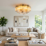 Cassian Tiered Fluted Glass Ceiling Light | Tiered Fluted Glass and Gold Brass | Displayed in a minimalist living room above a cream couch and a large neutral abstract painting | Severn Lighting