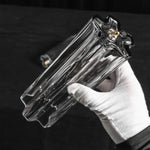 Cassian Tiered Fluted Glass Ceiling Light | Tiered Fluted Glass and Gold Brass | A hand wearing a white glove holding a single clear fluted glass rod component against a dark background | Severn Lighting