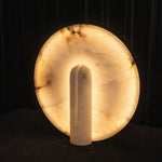 Elvire Alabaster Disc Table Lamp | Natural Alabaster | Front illuminated product view displayed against a dark studio background | Severn Lighting
