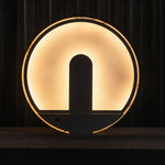 Elvire Alabaster Disc Table Lamp | Natural Alabaster | Backlit silhouette view highlighting the glowing circular disc design | Severn Lighting