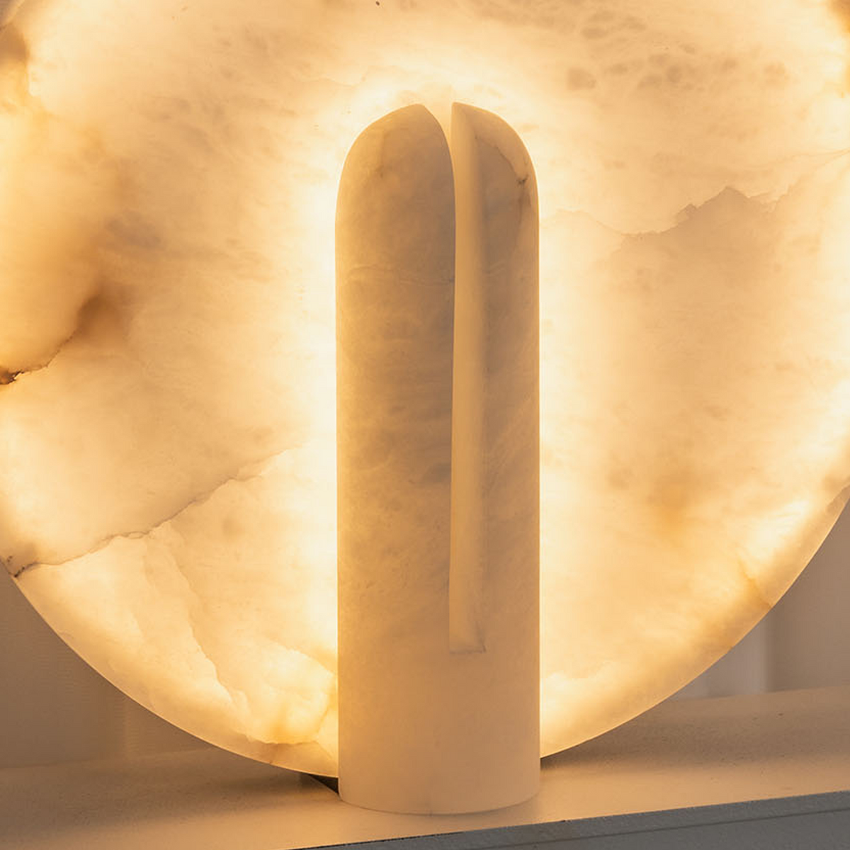 Elvire Alabaster Disc Table Lamp | Natural Alabaster | Close-up front view highlighting the illuminated stone texture and stem | Severn Lighting
