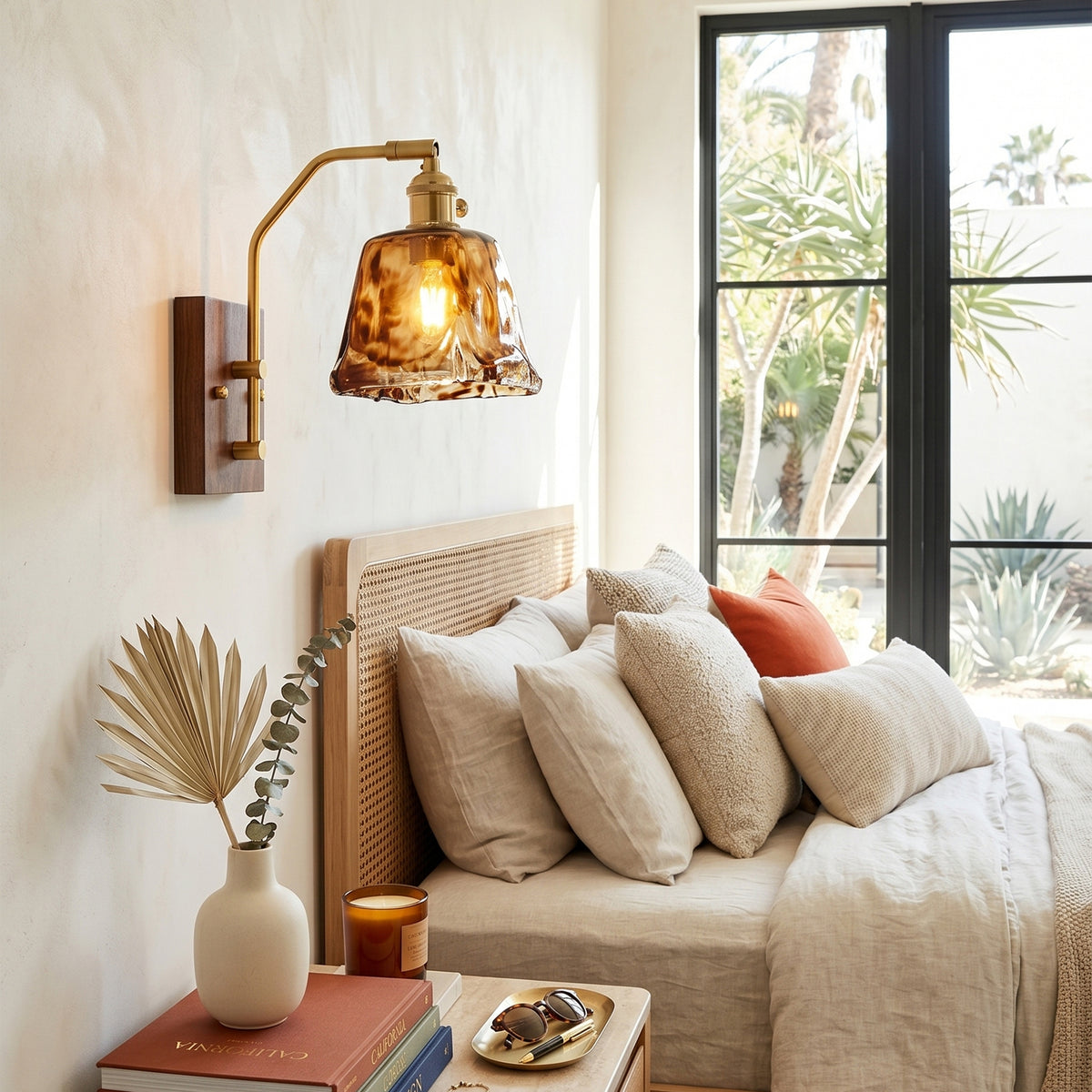 Everett Amber Ripple Wall Sconce | Amber Rippled Glass and Walnut Wood | Installed above a wooden nightstand in a cozy bedroom next to a bed with neutral linens | Severn Lighting