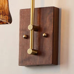 Everett Amber Ripple Wall Sconce | Amber Rippled Glass and Walnut Wood | Macro shot focusing on the rich texture of the rectangular walnut wood backplate | Severn Lighting